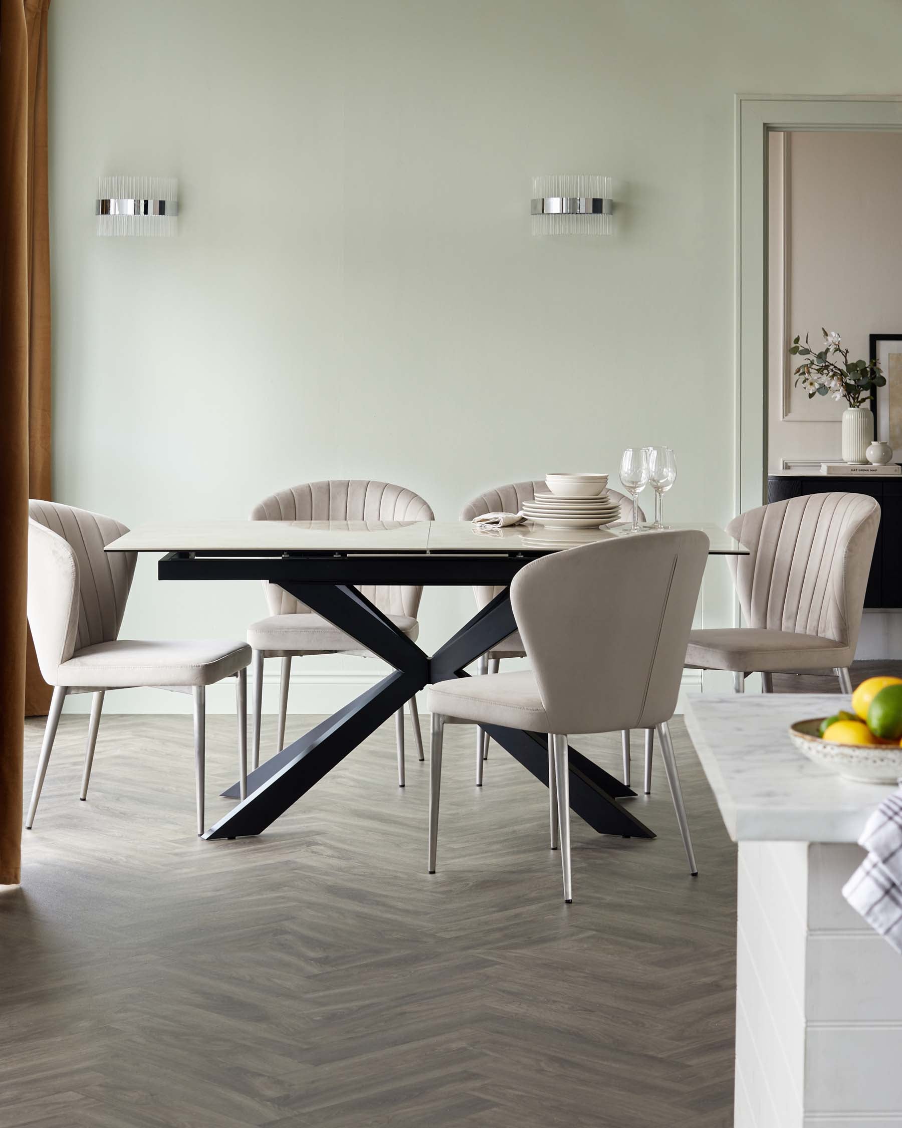 Modern dining set featuring a light-colored table with an X-shaped base and sleek, upholstered chairs in soft tones.