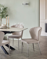 Elegant dining set featuring a glass-top table, sleek metal chairs with plush upholstery, and tasteful decor elements.