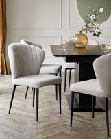 Elegant dining room set featuring a dark wood rectangular table with a ribbed central support panel and sleek black legs, paired with four light grey upholstered chairs with channel tufting on the high seat backs and black legs.