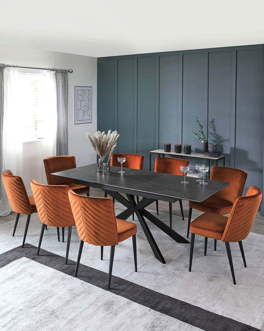 A modern dining set featuring a sleek black table and six stylish orange velvet chairs with a textured pattern, set on a light rug.