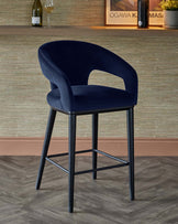 Navy blue upholstered barstool with a curved back and open arms, featuring a sleek black metal frame and footrest.