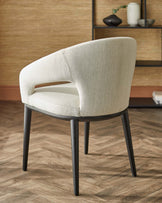 Curved, upholstered chair with a light fabric and black wooden legs, showcasing a modern and elegant design.