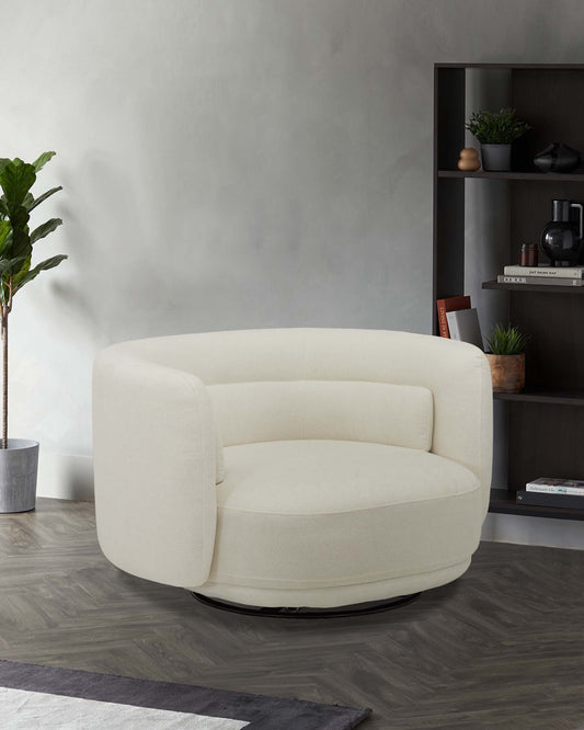 A plush, cream-colored swivel chair with rounded edges, paired with a sleek black shelving unit displaying decorative items.