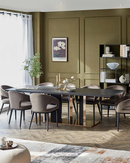 Stylish dining table with sleek black finish, paired with plush, rounded gray chairs, set against a warm green wall.