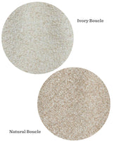 Two fabric swatches in circular shapes with text labels. The top swatch is labelled "Ivory Boucle" and has a cream-colored, textured fabric appearance. The bottom swatch is labelled "Natural Boucle" and features a beige, textured fabric appearance.