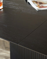 Dark brown wooden dining table with a textured surface and vertical fluted details on the table's side panel.