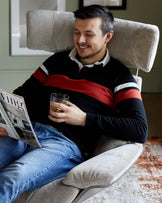 Plush, high-back grey accent chair with a wide seat, sleek armrests, and a padded headrest.