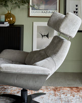 Modern grey upholstered recliner chair with adjustable headrest and sleek black swivel base, placed in a contemporary living room setting.