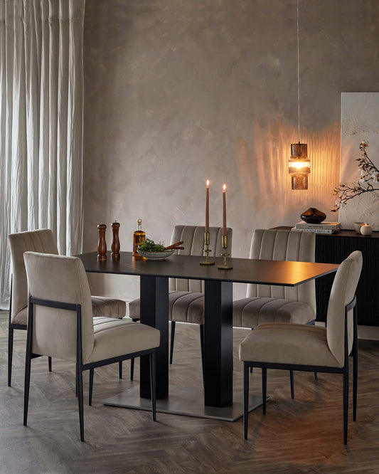 A sleek black dining table with elegant velvet chairs, complemented by candles and stylish decor, enhancing a modern ambiance.