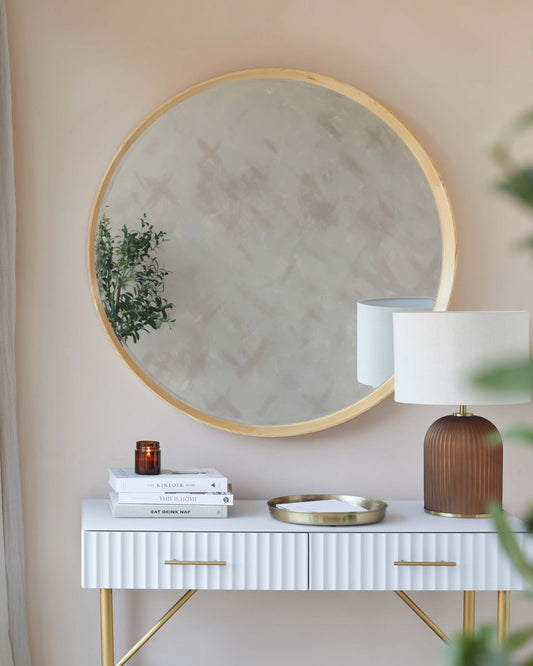 Elegant white console table with ribbed detail and gold handles, supported by slender brass legs.