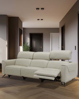 A sleek, light beige reclining sofa featuring adjustable headrests and a pull-out footrest, set in a modern interior.