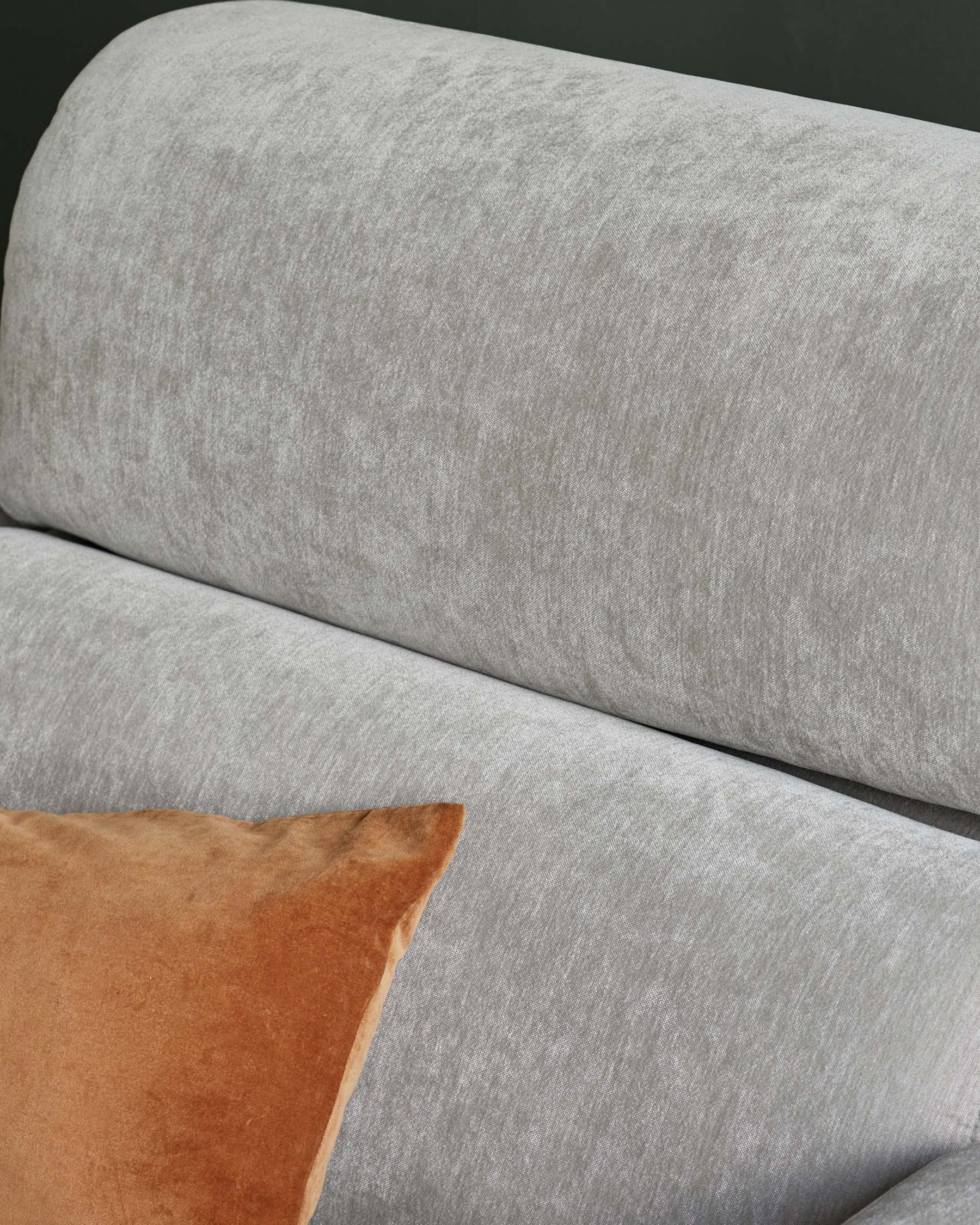 Light gray upholstered sofa with a plush texture, featuring a contrasting orange velvet cushion for added comfort and style.