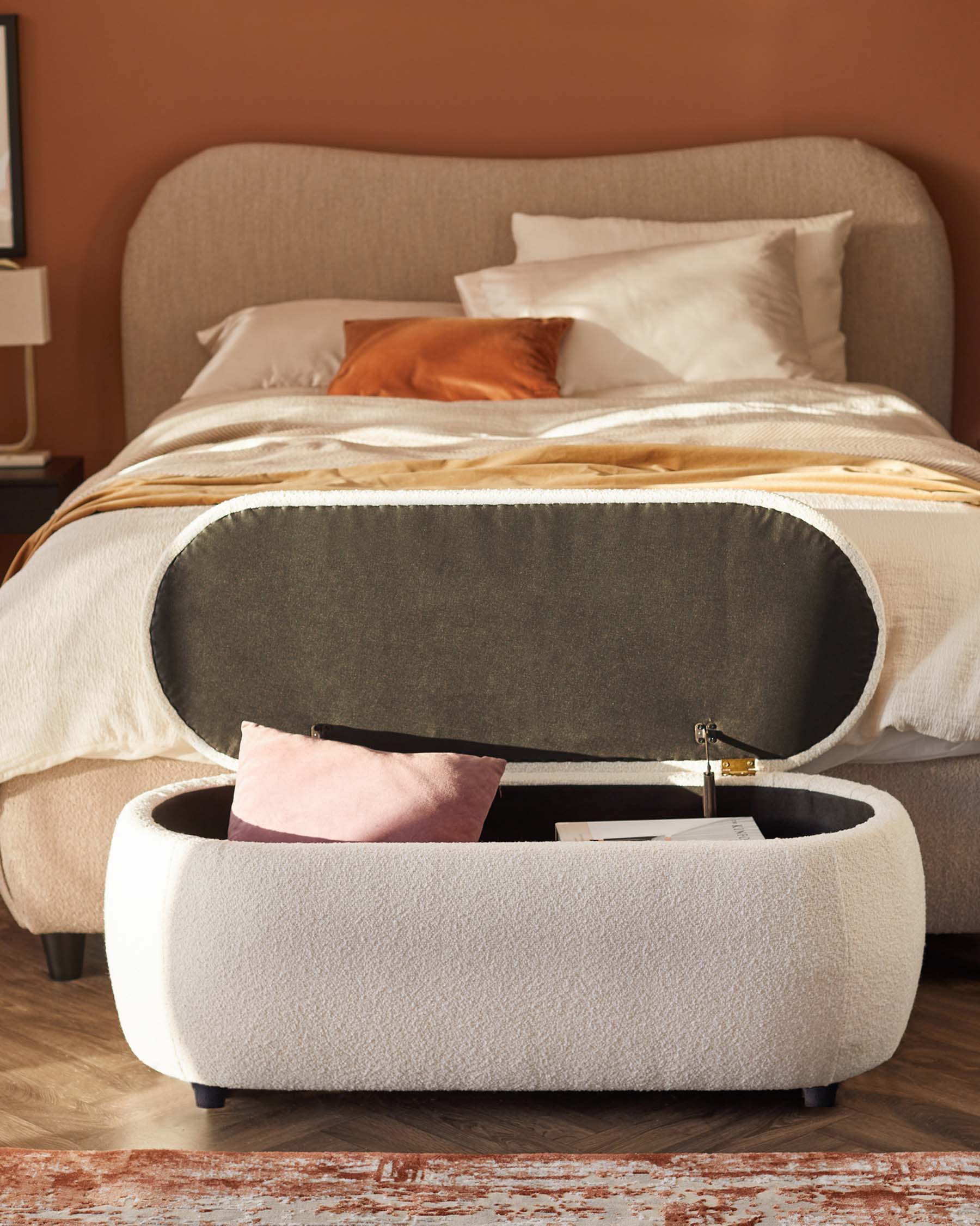 A cozy, upholstered bed with a soft headboard and a stylish storage ottoman, featuring a plush fabric and hidden storage compartment.