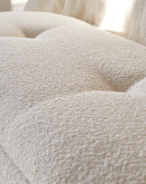 Textured beige upholstery with tufted detailing, offering a soft and inviting look, ideal for modern living spaces.