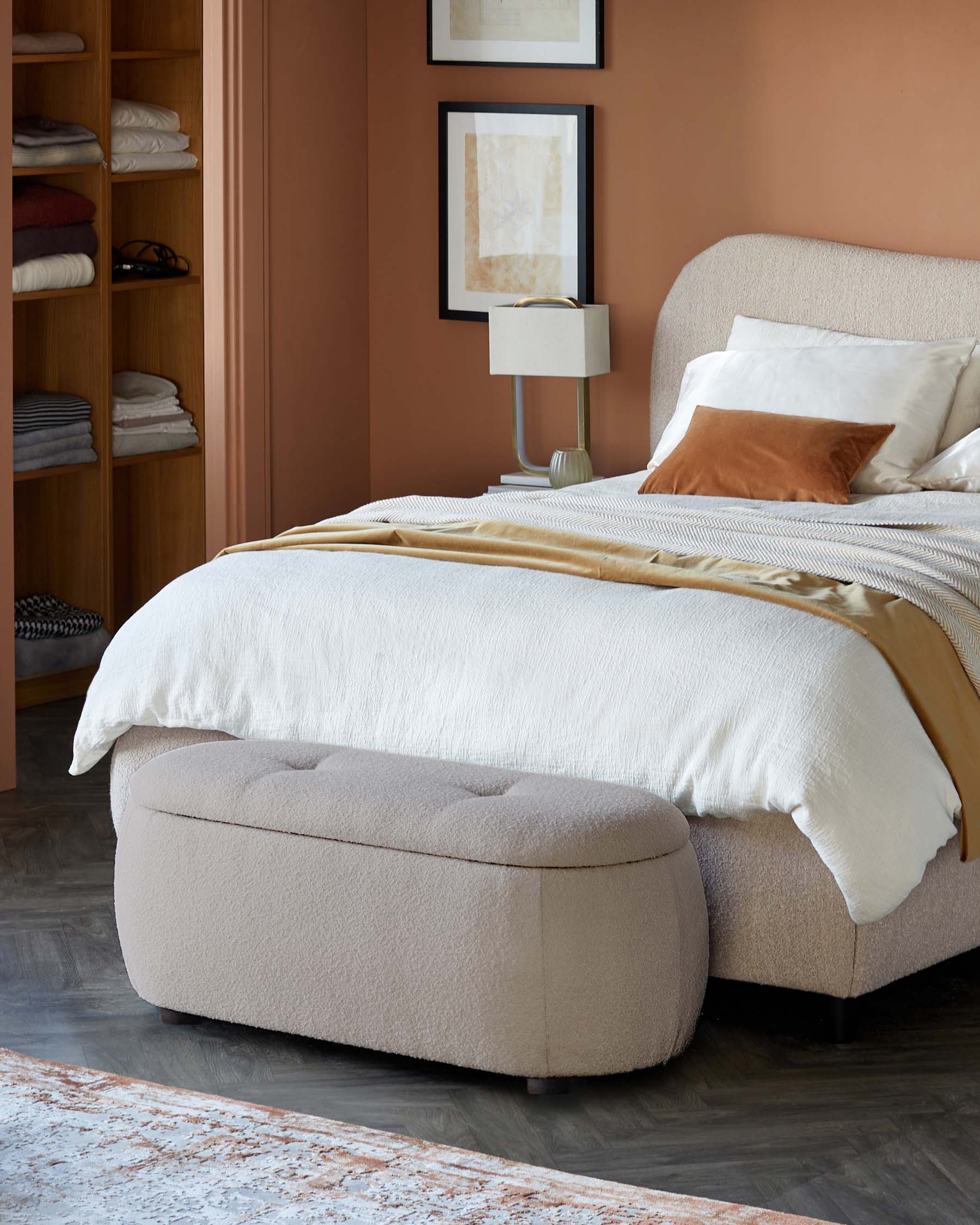 Cozy bedroom featuring a textured beige bed, plush bedding, and a matching upholstered bench at the foot of the bed.