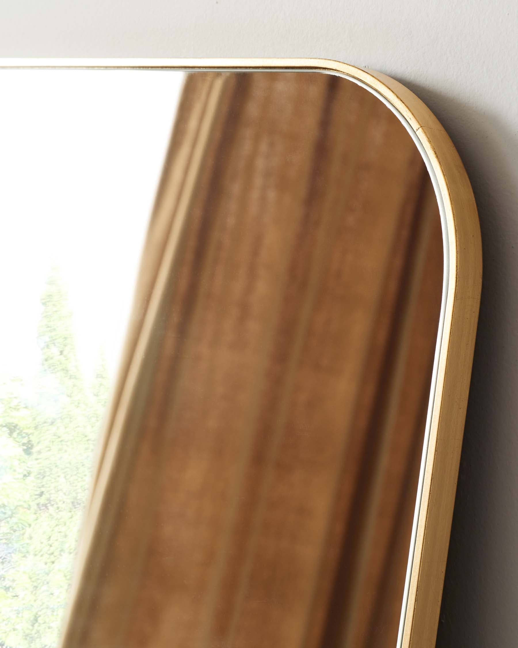 Elegant, minimalist wooden-framed mirror with a curved top and natural wood grain finish, bordered by a slim, light-toned trim.