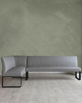 A modern gray leather sectional sofa with sleek black metal legs, offering a minimalist design for contemporary spaces.