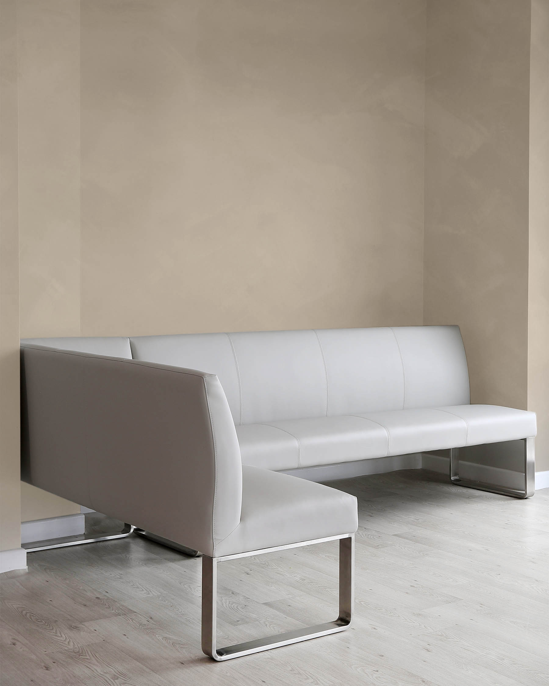 Modern minimalist light grey three-seater sofa with a sleek profile and metallic square frame legs displayed against a neutral background, suggesting a contemporary and sophisticated style.