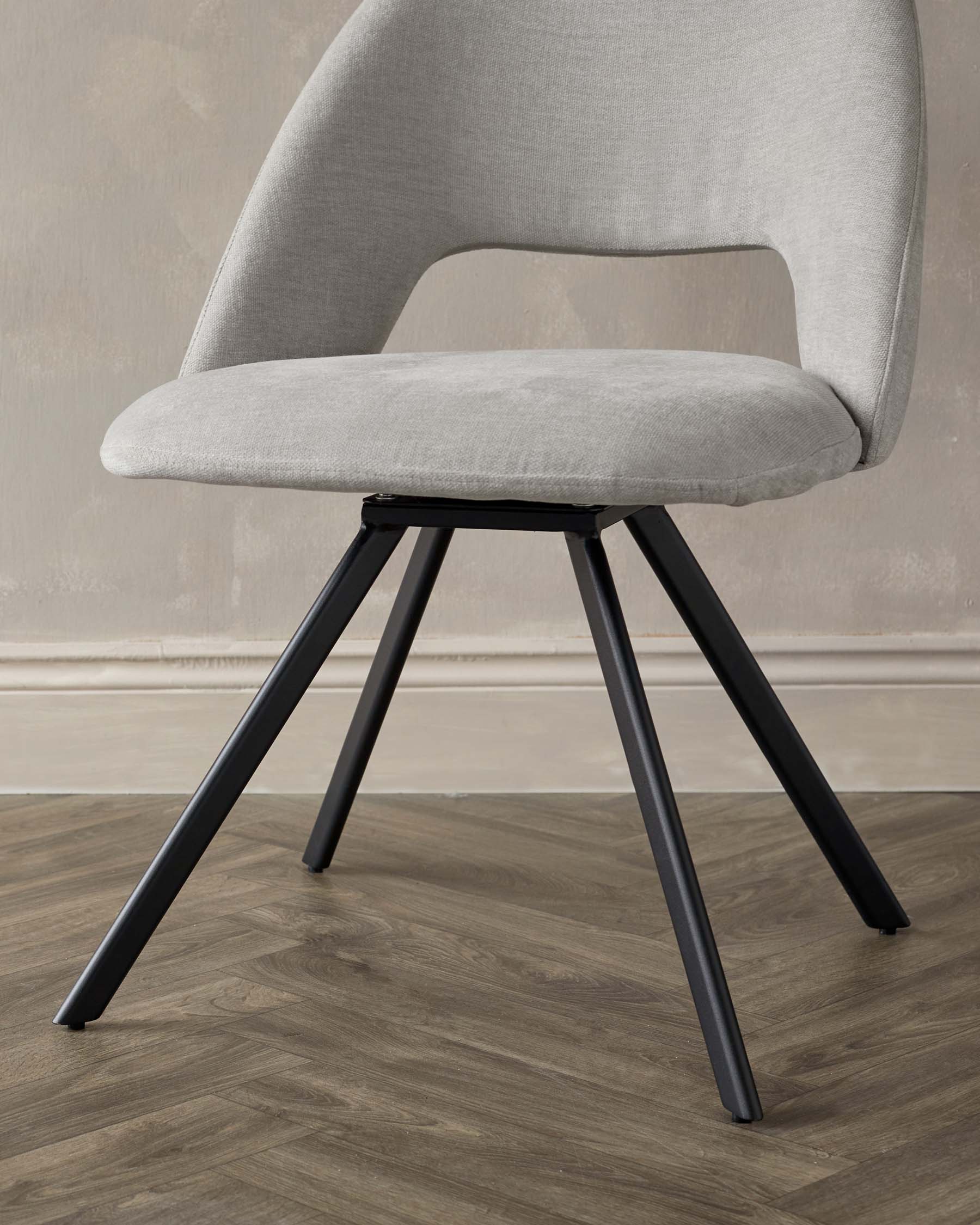 Modern minimalist chair with a heather grey fabric upholstery and a curved backrest. The chair stands on four splayed black metal legs.