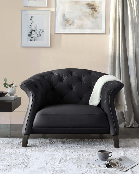 Elegant black tufted armchair with curved arms, paired with a side table and decorative elements, set against a light wall.