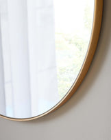 Round mirror with a thin gold frame.