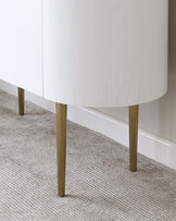 Modern minimalist white cabinet with sleek brass-finished tapered legs.