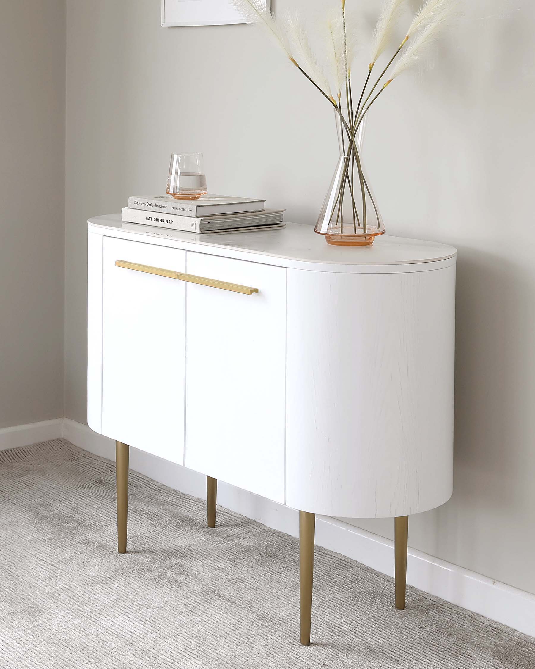 Elegant white curved sideboard with gold-finished metal legs and a long horizontal handle on the cabinet door.