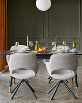 A modern dining set featuring a sleek, dark wood table coupled with four plush, textured fabric upholstered chairs with unique black legs tipped with brass accents. The chairs exhibit a cosy, yet stylish armchair design that enhances both comfort and visual appeal.