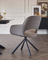 A modern swivel chair with a textured grey and beige upholstery and a black five-star base.