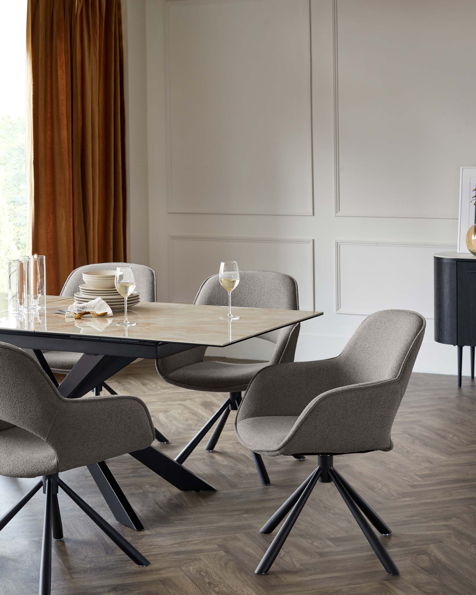 Modern dining room set featuring a minimalist rectangular table with a natural wood top and black metal legs arranged with four elegant upholstered swivel chairs in a textured grey fabric complemented by sleek black bases. The table is accessorized with simple dinnerware and glasses, providing a refined yet functional aesthetic.