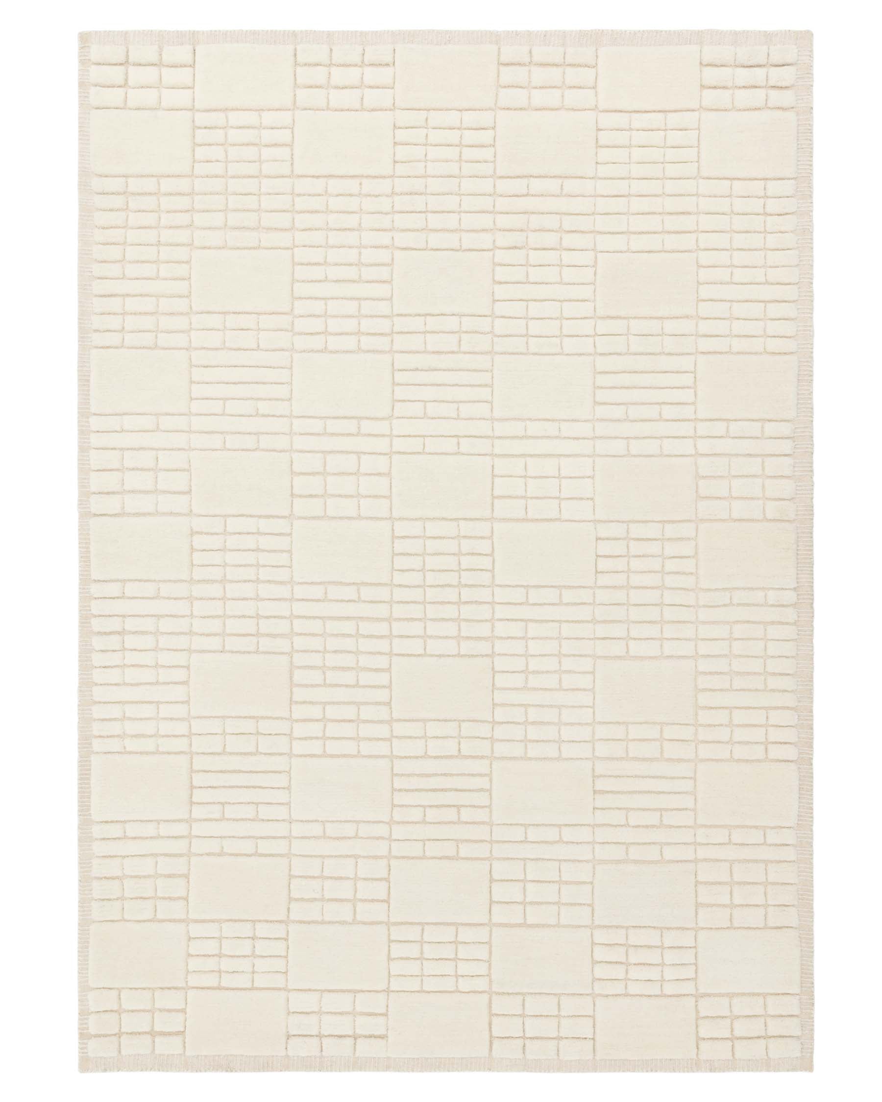 Cream-colored area rug with a textured geometric block pattern and fringe on the shorter edges.