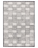 Monochromatic geometric patterned area rug with fringe detailing on the edges.