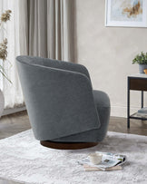 A stylish gray swivel chair with a curved design, accompanied by a small table and decorative elements in a cozy living space.