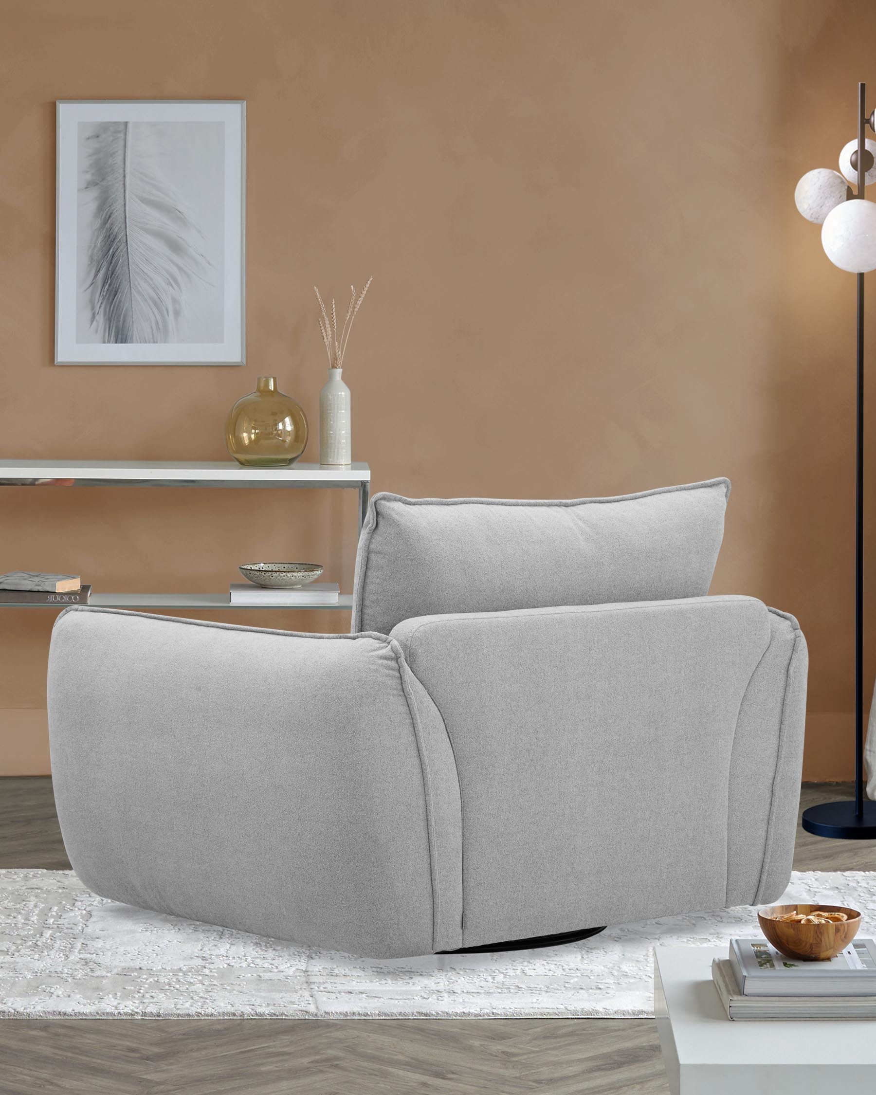 A soft gray armchair with plush cushioning, a sleek white shelf, and decorative elements on a textured rug in a modern setting.