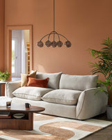 Cozy beige sofa with plush cushions, stylish wood coffee table, modern pendant light, and a decorative area rug.