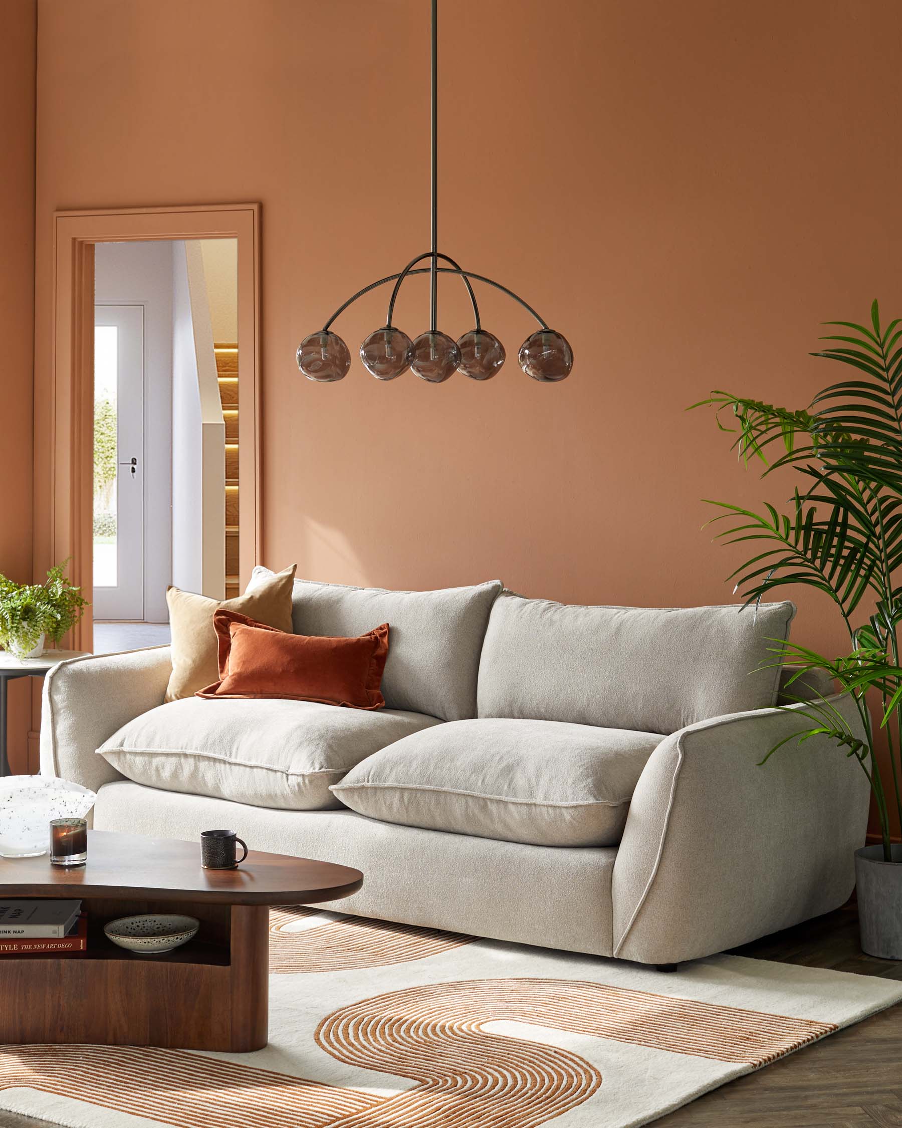 Cozy beige sofa with plush cushions, stylish wood coffee table, modern pendant light, and a decorative area rug.