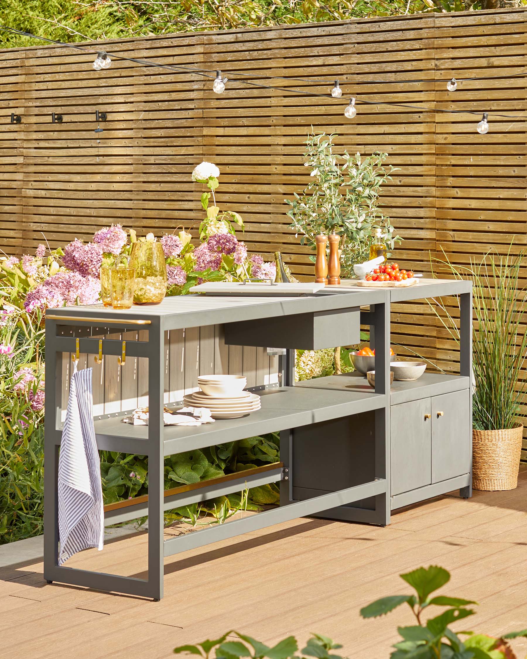 Stylish outdoor sideboard with gray finish, open shelves, storage cabinets, and decorative accents, perfect for entertaining.