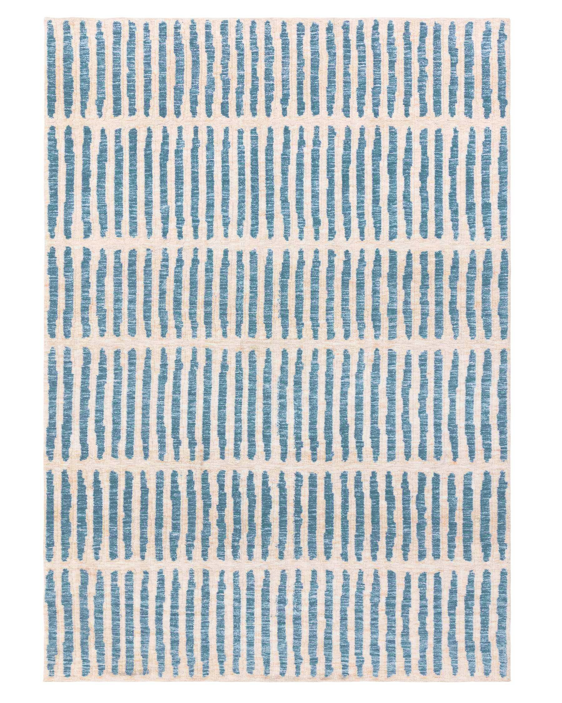 Rectangular area rug with an abstract blue stripe pattern on an off-white background.