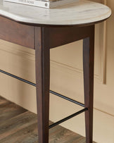 Elegant console table with a marble top and dark wooden legs, featuring a sleek black metal support bar.