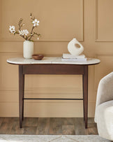 A stylish console table with a marble top, dark wooden legs, and decorative accents like a vase and books.