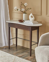 Elegant console table with a marble top, dark wood legs, and decorative elements like a vase, books, and a small bowl.