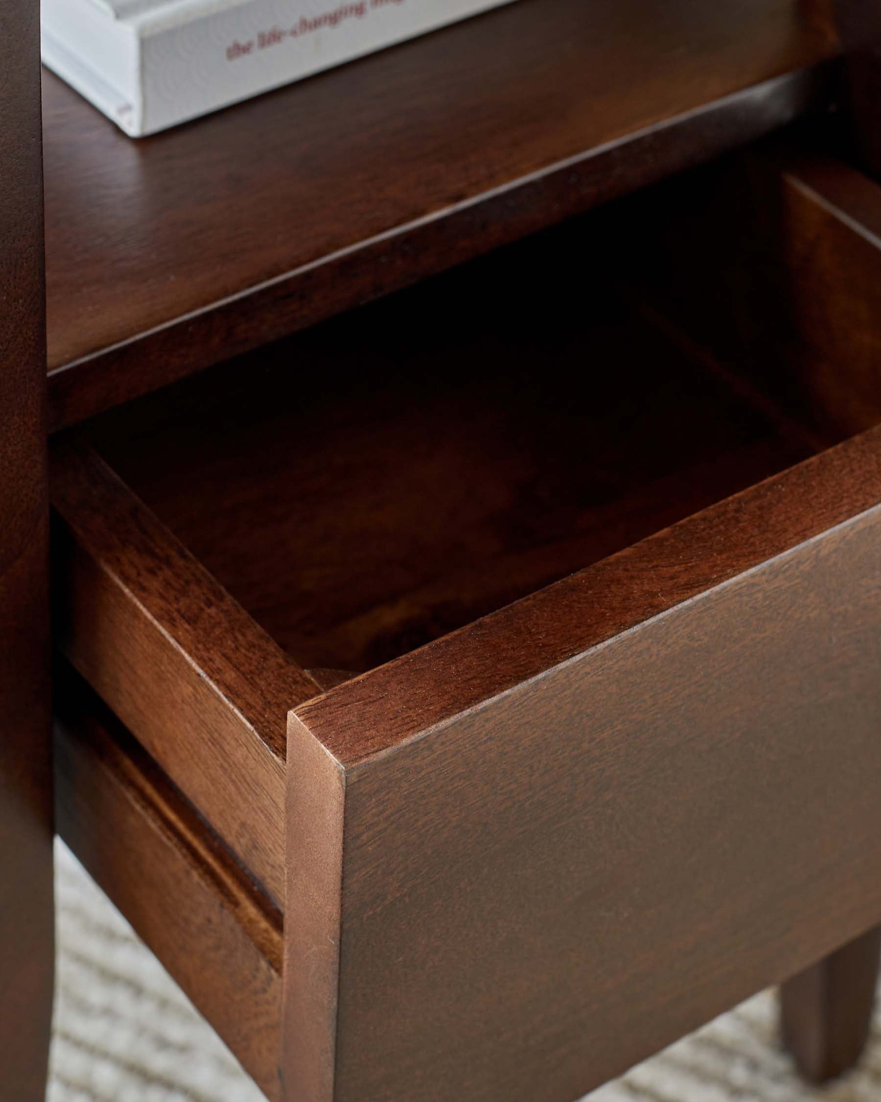 A stylish wooden nightstand featuring a smooth finish, an open drawer, and a minimalist design, perfect for modern decor.