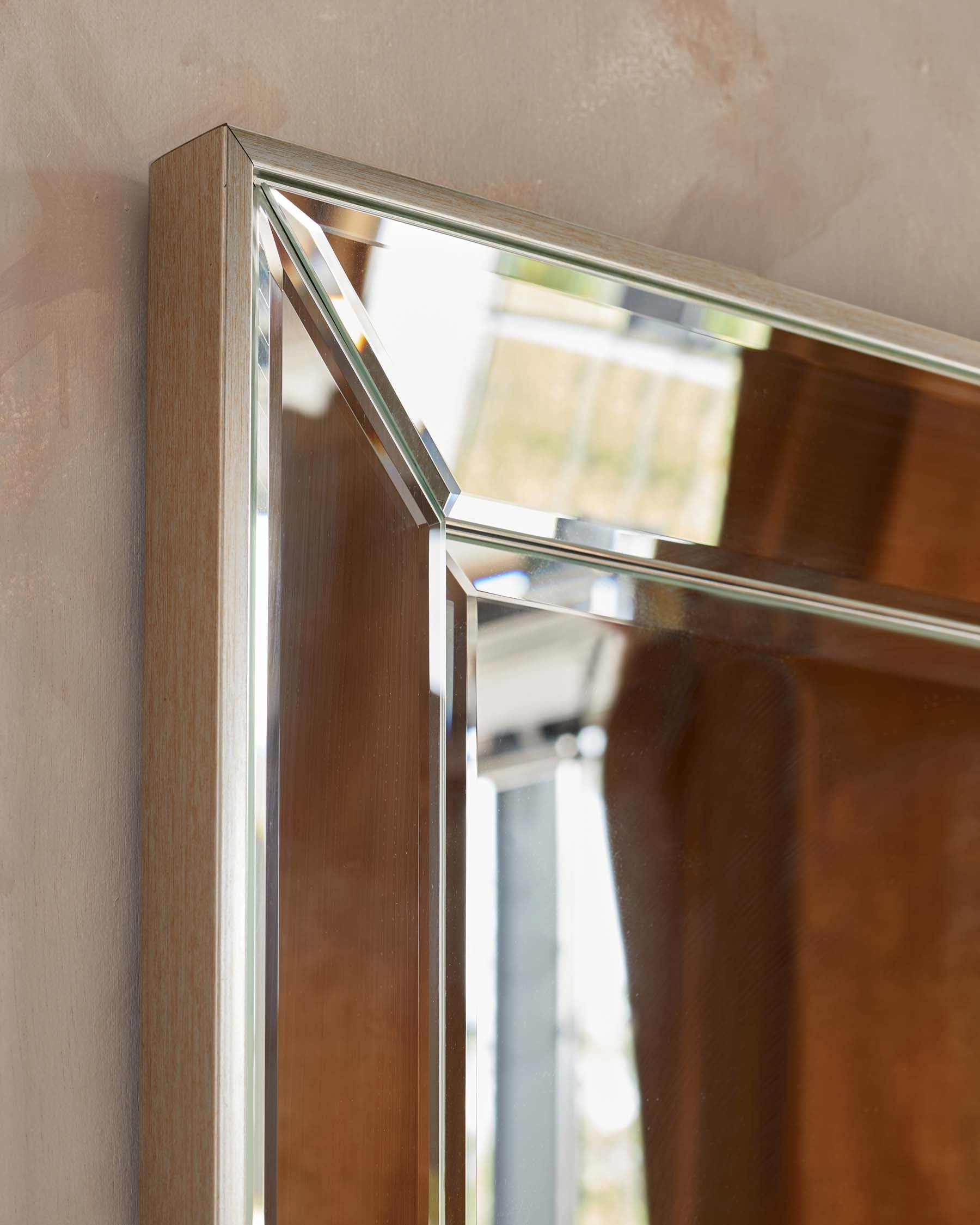 Close-up of a wooden frame with sleek metallic trim detailing, suggesting a modern and minimalist design aesthetic.