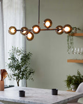 Marble dining table with a sleek rectangular top and a unique curved edge design, standing in an elegant dining room setting accentuated by a modern spherical chandelier above.