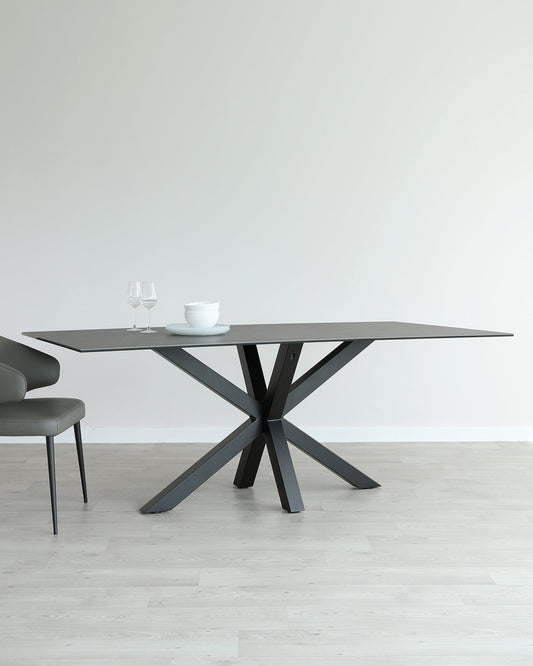 A modern gray dining table with an artistic crossed base, paired with a sleek gray chair, showcasing elegant simplicity.