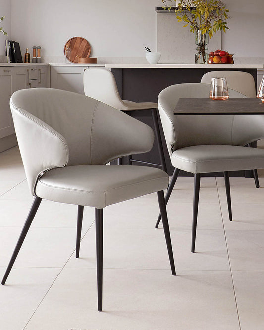 Stylish grey dining chairs with sleek black legs, paired with a modern table, create a chic and contemporary dining space.