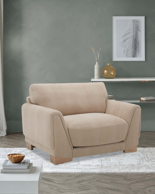 A beige armchair with a plush cushion and contemporary lines, accompanied by a side table, decor vase, and framed artwork.