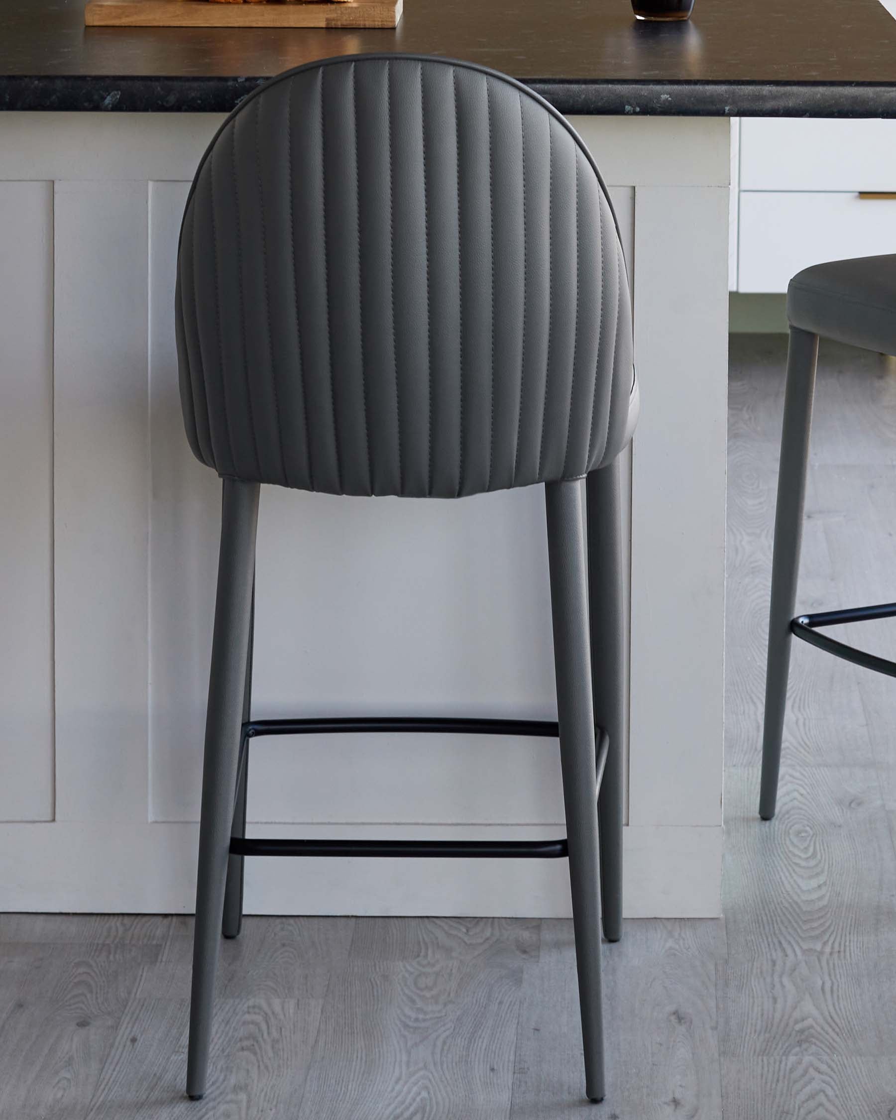 Modern grey bar stool with a textured, padded backrest and sleek metal legs, perfect for contemporary spaces.