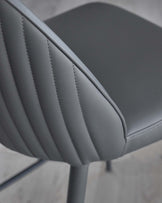 Stylish gray chair with a sleek, ribbed backrest and modern design, ideal for contemporary spaces.