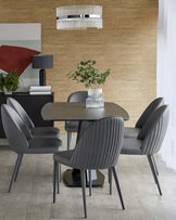 A modern dining set featuring a sleek table and four gray ribbed chairs, complemented by a stylish ceiling light and decorative plants.